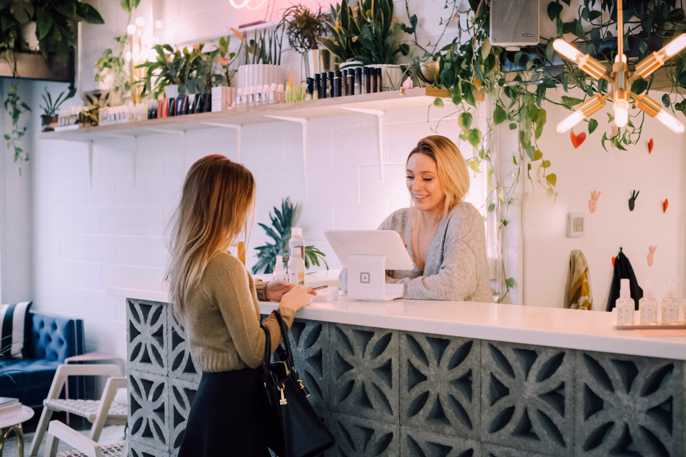 A receptionist serving a customer at a bright front desk