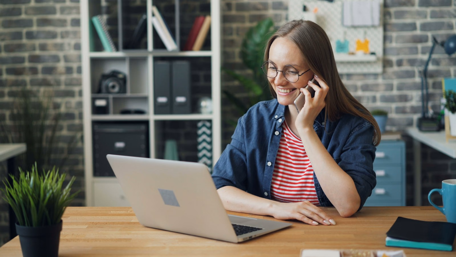 A business owner on the phone at her desk, smiling